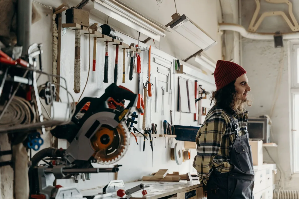 Un artisan travaille seul devant son établi dans un atelier de menuiserie Un artisan travaille seul devant son établi dans un atelier de menuiserie
