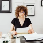 Un actif lit une lettre de fin de contrat de travail et des documents d'assurance sur son bureau