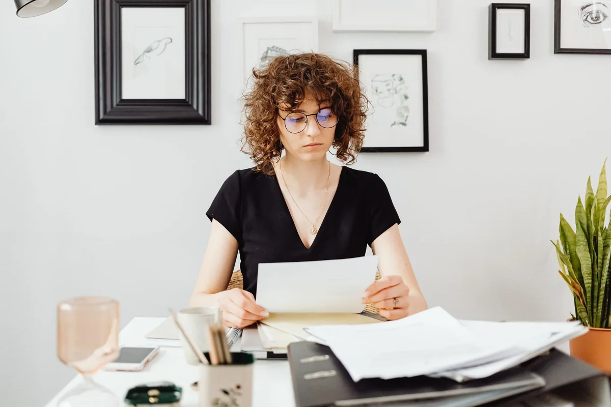 Un actif lit une lettre de fin de contrat de travail et des documents d'assurance sur son bureau