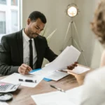Un homme d'une cinquantaine d'années examine des documents de prêt immobilier avec un conseiller bancaire