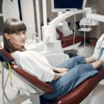 Une patiente adulte portant un appareil dentaire fixe assise dans le fauteuil d'un cabinet d'orthodontie