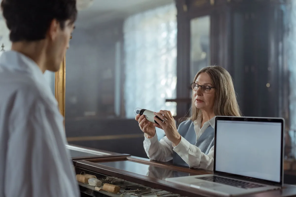 Un opticien présente une paire de lunettes à verres unifocaux à un client dans son magasin